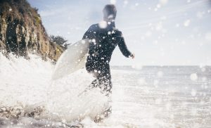 surfer running into the water