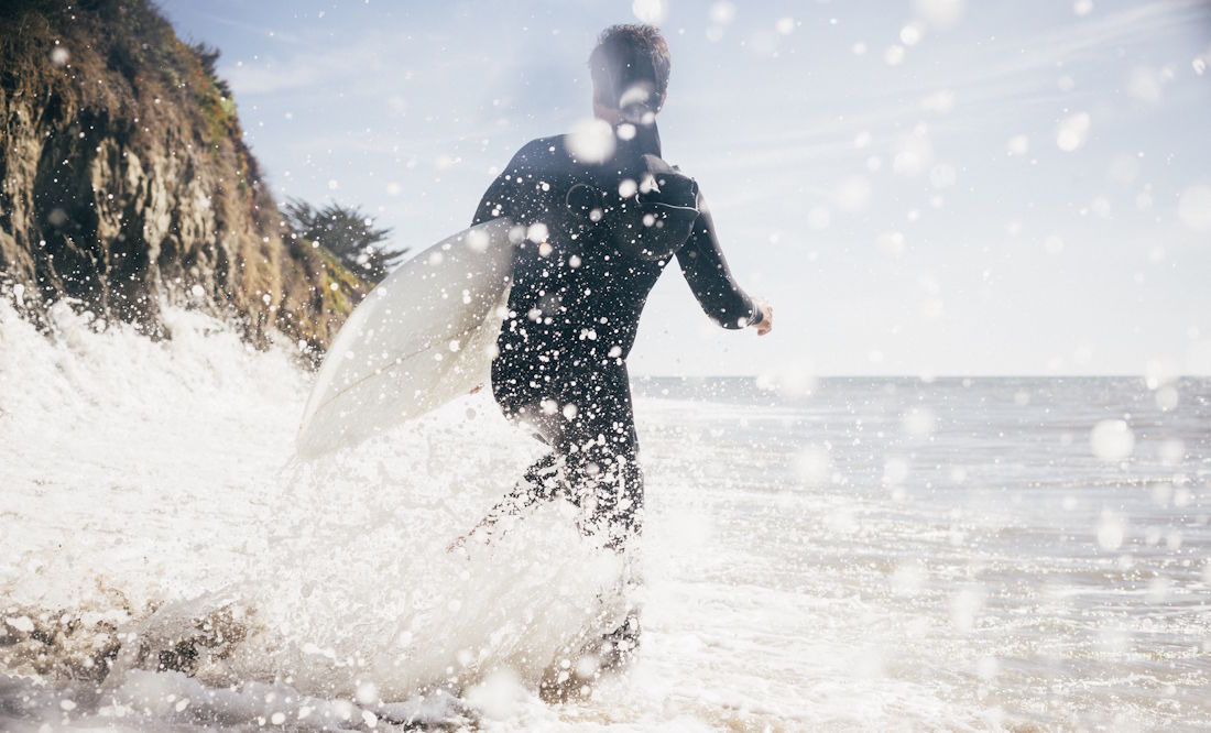 surfer running into the water